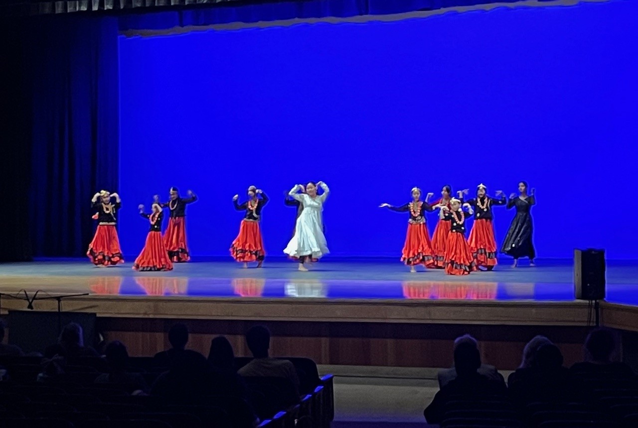 student dancers on stage in red, black and white dresses as they perform at the CFHS cultural event