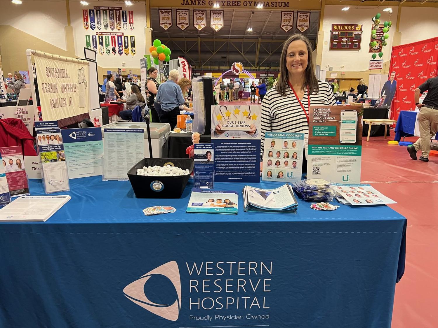 Kathy Romito Rainone stands at Western Reserve Hospital's table at the Stow Expo 